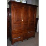 A 19th century oak press cupboard, the moulded cornice above two panelled cupboard doors, on a base