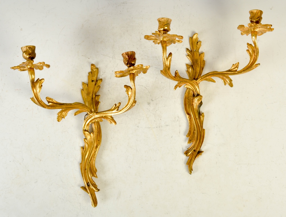 A pair of late 19th/ early 20th century gilt metal Rococo style two light wall sconces, 37cm long