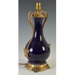 A Rococo style gilt metal mounted cobalt blue ground porcelain table lamp, the scroll handles cast