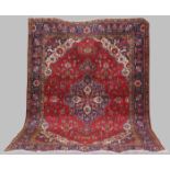 A Persian Carpet, Tabriz, 20th century, the rectangular madder ground centred with a blue