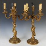 A pair of late 19th/ early 20th century gilt metal five light candelabras, with urn shaped nozzles