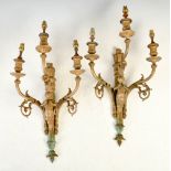 A pair of late 19th century gilt metal three light wall sconces, each cast with a cherub playing