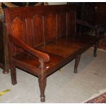 A George III oak settle, with fine panel back and planked seat raised on shaped supports, 185cm wide