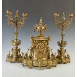 A late 19th century gilt metal clock garniture, the clock with enamelled Roman numeral panels and