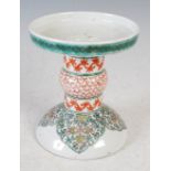 A Chinese porcelain candle holder stand, decorated with ruyi shaped panels enclosing flowers and