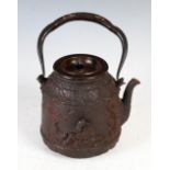 A Japanese Iron kettle and cover (Tetsubin), Meiji Period, cast in relief with a Chinese scholar
