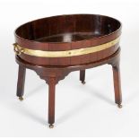 A late 18th/ 19th century mahogany and brass-bound wine cooler, the oval-shaped cooler with single