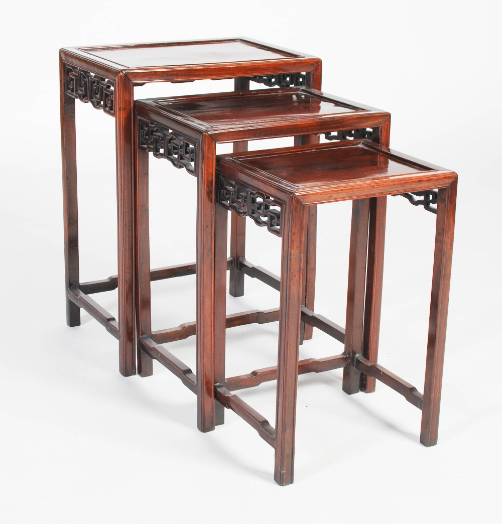 A nest of three Chinese dark wood occasional tables, late 19th/ early 20th century, the