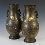 A pair of Japanese bronze twin handled pear shaped vases, late 19th/ early 20th century, decorated