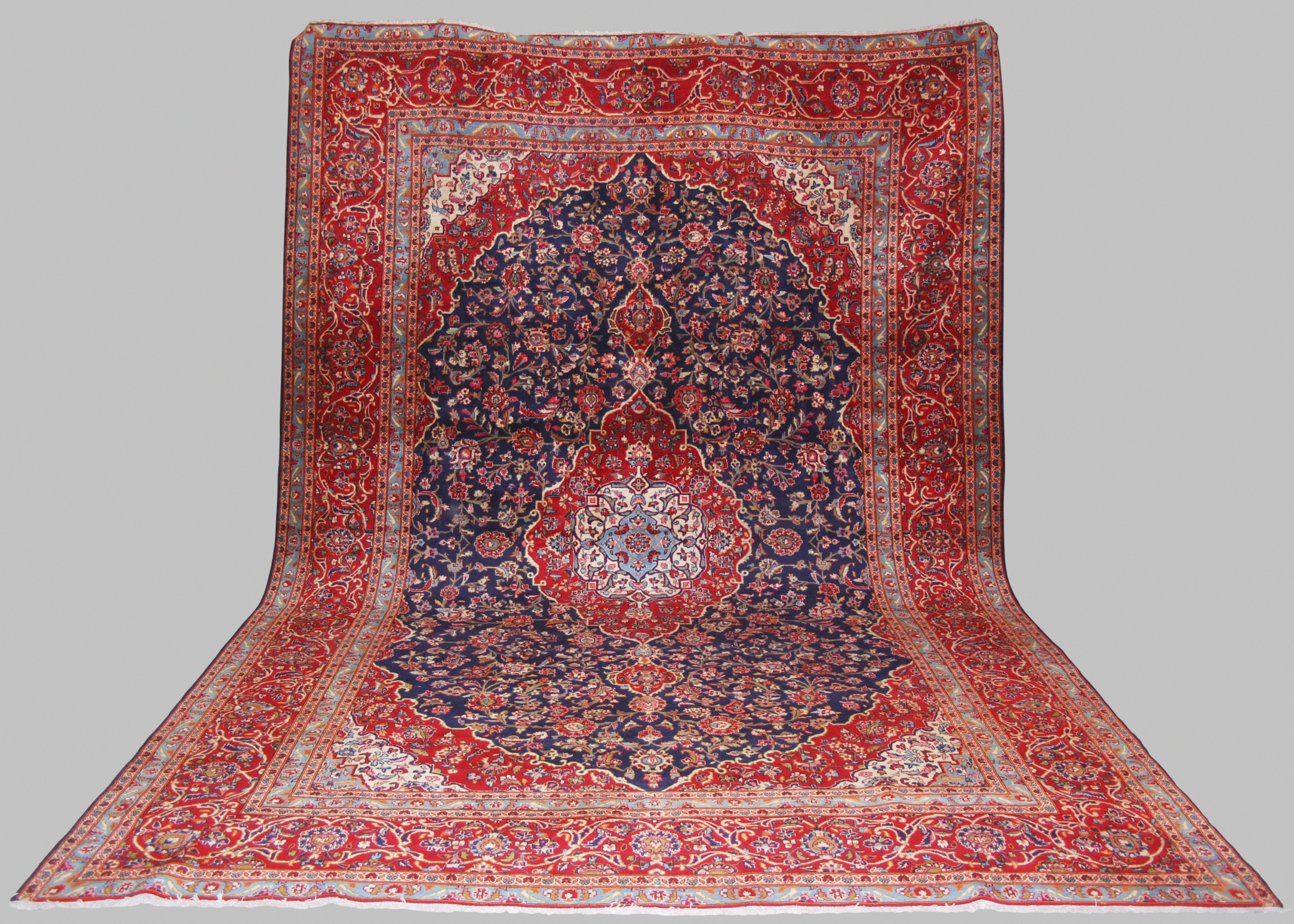 A Persian carpet, Kashan, 20th century, the rectangular blue ground field centred with an oval-