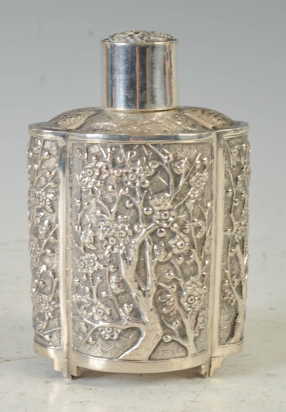 A late 19th/ early 20th century Chinese silver quatrefoil shaped tea caddy, WANG HING, with embossed