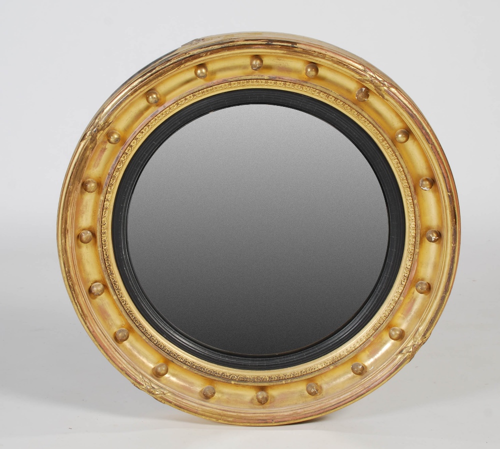 A 19th century giltwood mirror, the circular convex mirror plate within ball-set frieze, 58cm