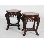 A pair of Chinese darkwood jardiniere stands, Qing Dynasty, the circular tops with marble inserts