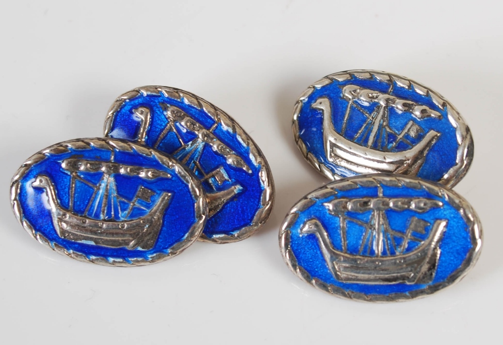 A pair of silver and blue enamel cufflinks after a design by Alexander Ritchie, the oval shaped