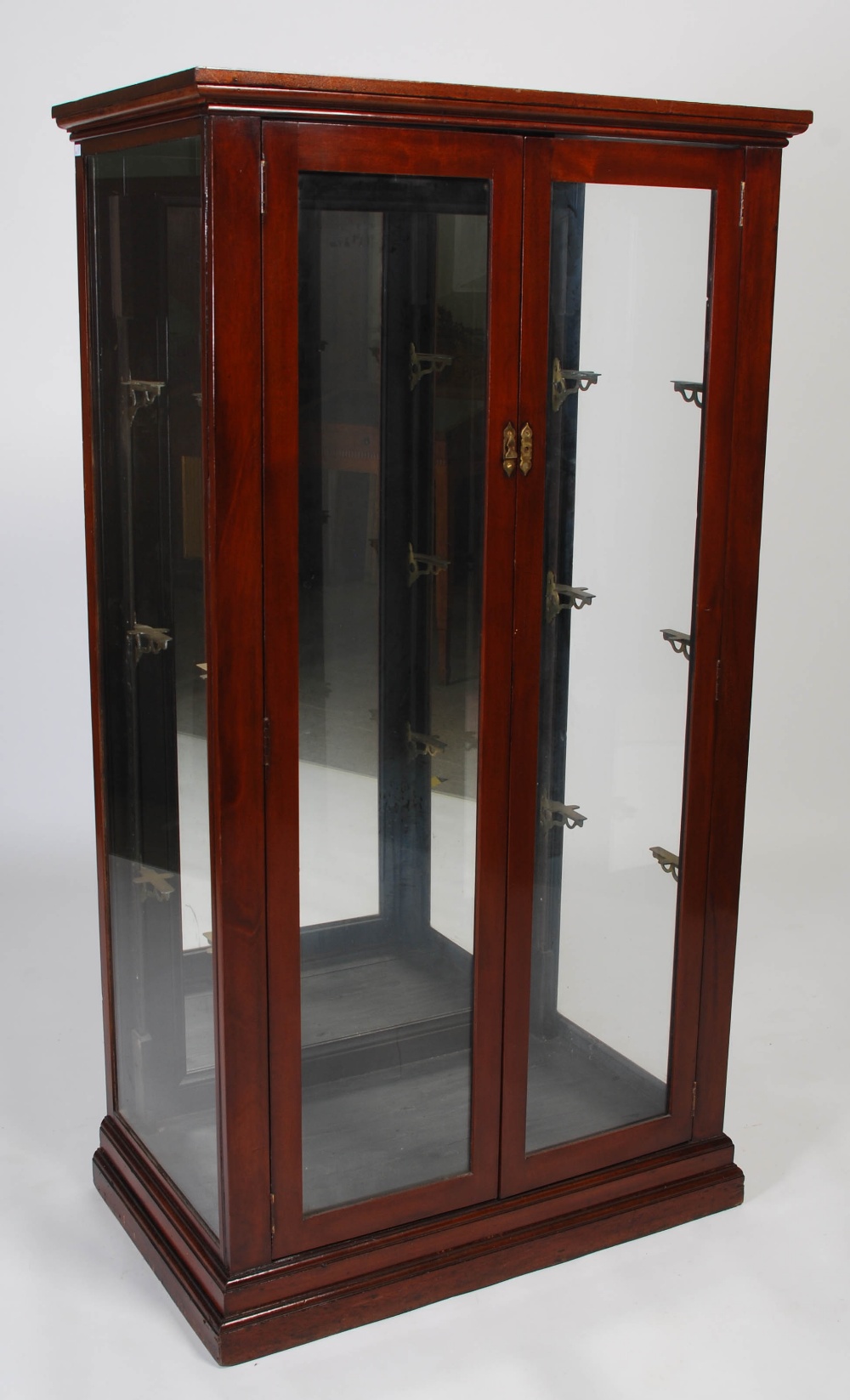 An early 20th century mahogany mirror back display cabinet, the moulded cornice above a pair of