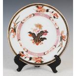 A Chinese porcelain famille rose plate, Qing Dynasty, decorated with peony spray in a panelled