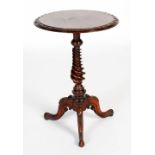A 19th century walnut occasional table, the circular top with foliate carved edge on a tapered