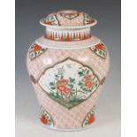A Chinese porcelain wucai jar and cover, decorated with three lozenge shaped panels enclosing peony,