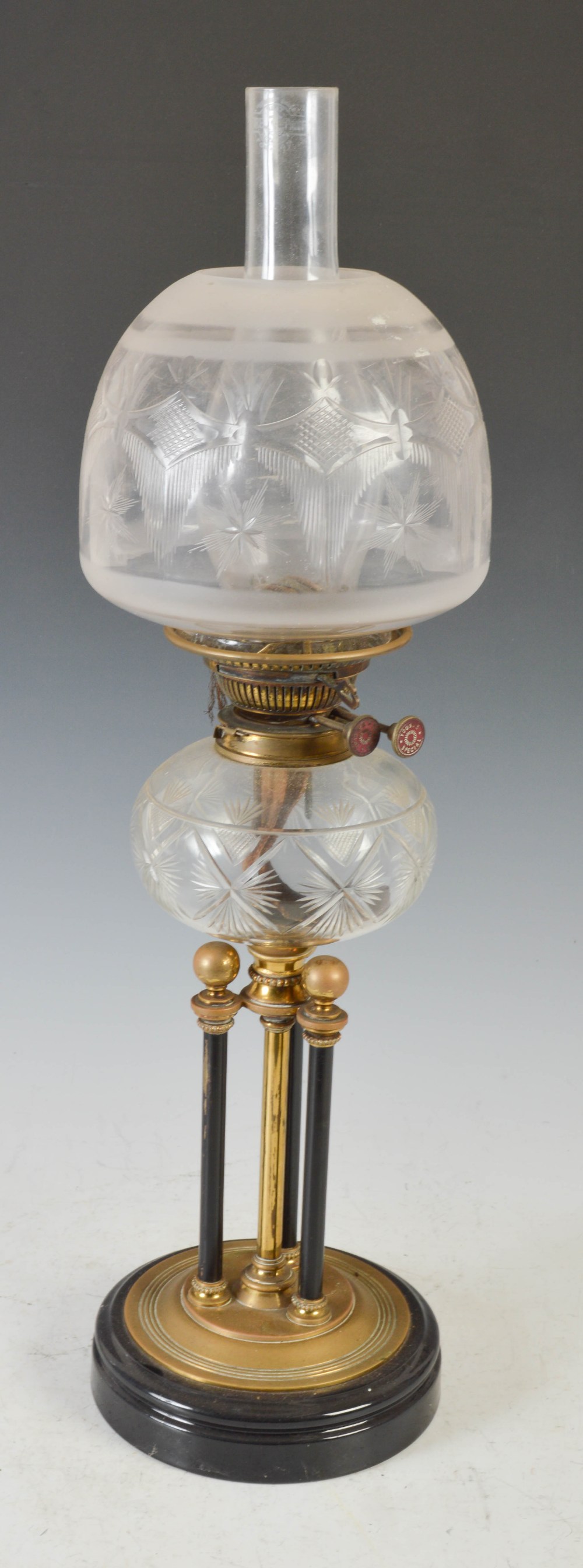 A late 19th/ early 20th century brass oil lamp, with clear and frosted cut glass shade, the burner