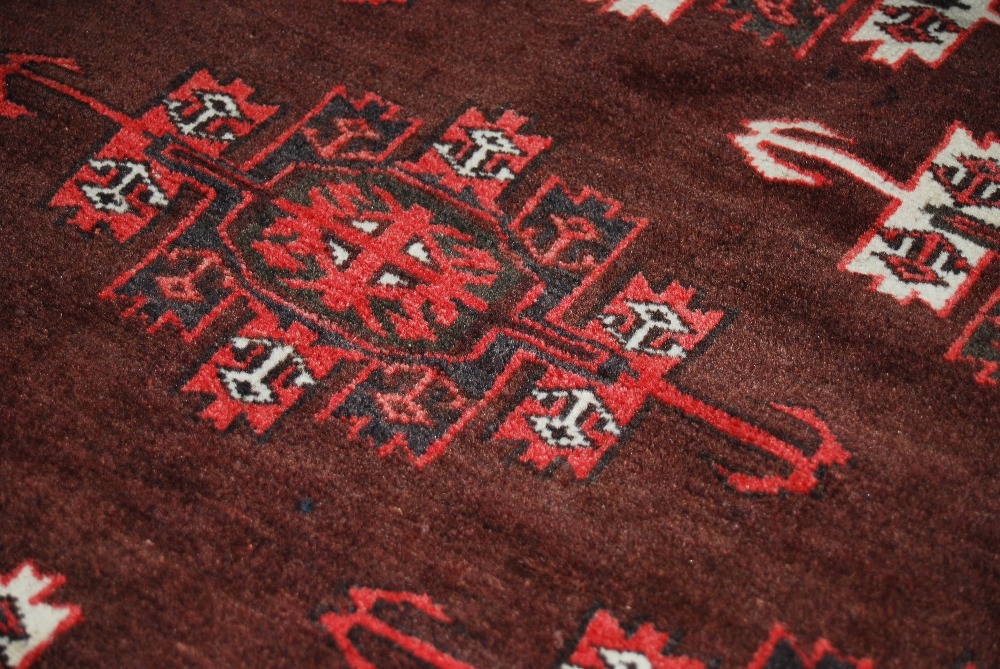 A Persian rug, 20th century, the earth coloured ground decorated with stylised octagonal shaped - Image 6 of 6
