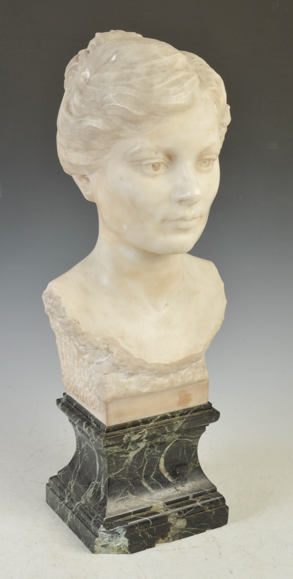 An early 20th century white marble bust of a lady, on green plinth base, 64cm high.