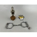 AA badge together with vintage handcuffs and metal figure of a knight