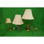 2 brass lamps together with a blue and white lamp