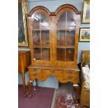 Queen Anne style walnut 2 domed bookcase with a glazed top sitting on cabriole legs on ball and claw