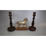 Metal figurine of horse on wooden base together with a pair of turned wooden candlesticks