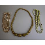 2 glass necklaces together with a string of cultured pearls