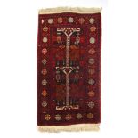 A handwoven Persian rug, the triple line border surrounding a red ground field,