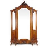 A 19th century French mahogany armoire, the carved cornice over a single bevelled mirror door,