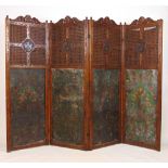A 19th century carved oak four fold screen with cane surrounding a carved armorial crest over