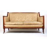 An early 20th century Regency style mahogany sofa upholstered in a rose gold floral fabric with
