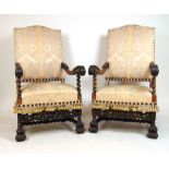 A pair of reproduction walnut and beech open arm chairs upholstered in a striped floral silk fabric,