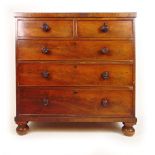 An early 19th century mahogany chest of two short over three long drawers with turned knobs on bun