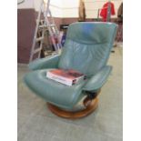 A green leather upholstered swivel Stressless chair with detachable swing table