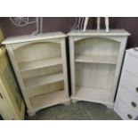 A pair of cream painted open bookshelves