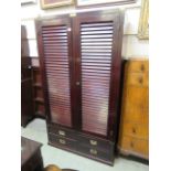 A Scandinavian mahogany wardrobe with slatted doors over four drawers on plinth base,