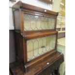 An early 20th century oak sectional bookcase with leaded glazed doors, comprising of cornice,