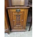 A carved oak cabinet with pull down front