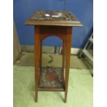 An early 20th century walnut jardiniere stand with carved top and under tier