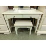 A white dressing table having two drawers along with a matching stool