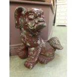 A composite stone garden figure of foo dog painted red