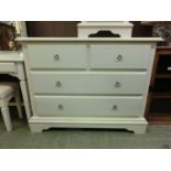 A white chest of two short over two long drawers