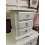 A white bedside chest of three drawers