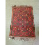A handwoven Caucasian rug, the main border with geometric design surrounding the red ground field,
