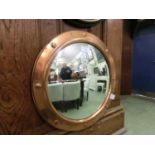 A circular copper framed convex mirror