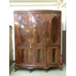 An Edwardian mahogany triple wardrobe, the doors with oval panels over blind fret and further panels