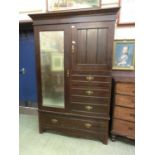 An early 20th century walnut wardrobe, the bevel mirrored door alongside cupboard door and three